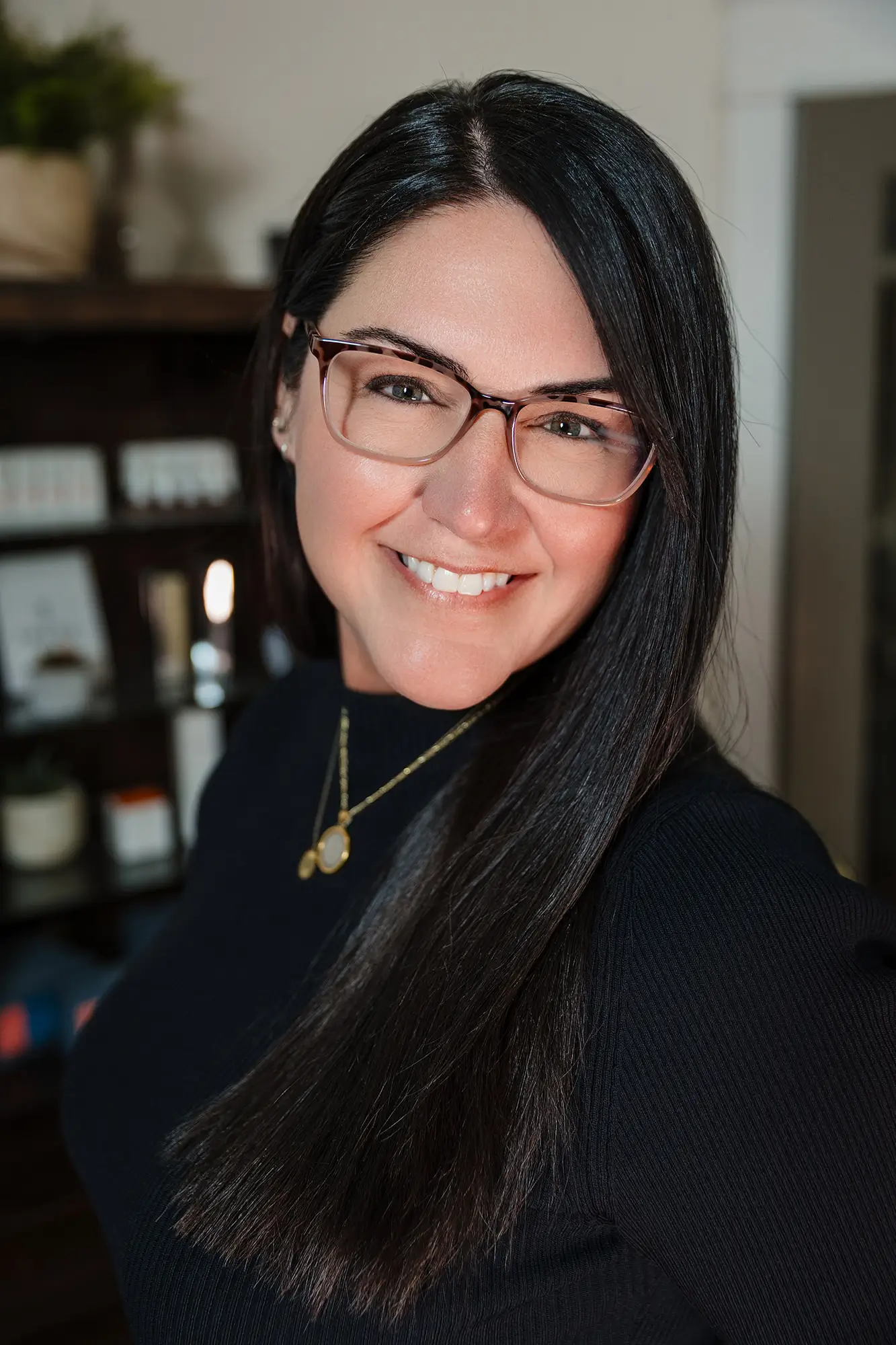 Stephanie, owner and laser specialist at Wichita Laser Clinic, smiling in glasses and a navy top inside the clinic