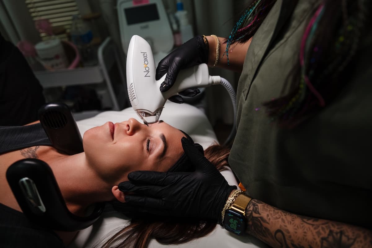 Wichita Laser Clinic specialist steadying a client's head while treating the forehead with the Tixel device